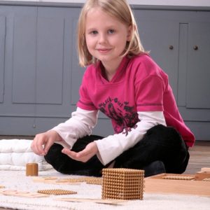 Montessori-Kid mit goldenem Perlenmaterial